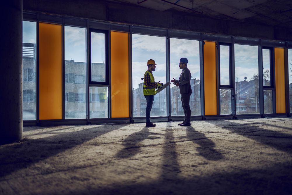 ouvrier et architecte près d'une fenêtre