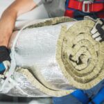 entrepreneur avec rouleau d'isolation en laine minérale